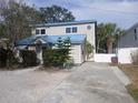 Exterior angle shot with a driveway and partial fencing; property has a unique facade and architectural detail at 2728 58Th S St, Gulfport, FL 33707