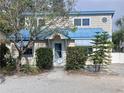 Inviting home entrance featuring well-maintained landscaping, white door, and blue awning, blending charm and curb appeal at 2728 58Th S St, Gulfport, FL 33707