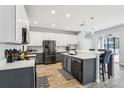 Modern kitchen featuring stainless steel appliances, dual-toned cabinets, and a spacious island with seating at 3046 Donington Castle Ln, Land O Lakes, FL 34638