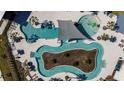 Aerial view of a community pool featuring a lazy river, lounge chairs, and ample space for relaxation at 31350 Pendleton Landing Cir, Wesley Chapel, FL 33545