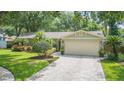 Well-maintained single-Gathering home with a lush front yard and a two-car garage at 3714 Village Estates Pl, Tampa, FL 33618
