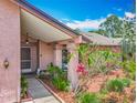 Charming covered front entrance features lush landscaping and inviting curb appeal at 3932 Watson Dr, New Port Richey, FL 34655