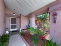 Charming covered front entrance features lush landscaping, and quaint decor at 3932 Watson Dr, New Port Richey, FL 34655
