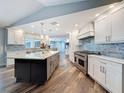 Beautiful kitchen featuring a large island, stainless appliances, white cabinets, and stylish tile backsplash at 44 Pinewood Cir, Safety Harbor, FL 34695