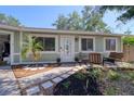 Inviting front yard with a charming walkway, tasteful landscaping, and an cozy outdoor seating area at 506 Summerwood Ct, Tarpon Springs, FL 34689