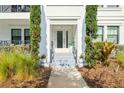 Inviting entryway with manicured plants and gray steps leading to a glass front door at 5351 Bridge St # 9, Tampa, FL 33611