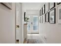 Bright hallway with modern decor and light wood floors leading to the front door at 5351 Bridge St # 9, Tampa, FL 33611
