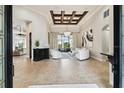 Bright and airy living room with tile flooring, coffered ceilings, modern furniture, and access to outdoor views at 5405 Tybee Island Dr, Apollo Beach, FL 33572