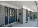 Close up of the front door featuring glass detailing and grey brick exterior with seating at 607 Carolyn Dr, Brandon, FL 33510