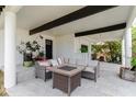 Covered outdoor patio showcasing comfortable seating around a stylish table with a stone accent wall at 7404 Bay Dr, Tampa, FL 33635