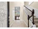 Inviting foyer with tile flooring and a staircase leading to the upper level at 7699 Windchase Way, Wesley Chapel, FL 33545