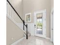 Elegant foyer with tile flooring and a beautiful staircase with black trim at 7699 Windchase Way, Wesley Chapel, FL 33545