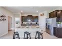Bright open kitchen featuring an island with seating and stainless steel appliances at 7763 Wheat Stone Dr, Zephyrhills, FL 33540