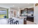 Kitchen featuring a large island, dark cabinets, and stainless steel appliances at 7763 Wheat Stone Dr, Zephyrhills, FL 33540