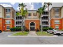 Exterior shot of condos with orange and beige siding, balconies, and manicured landscaping at 7901 Seminole Blvd # 1103, Seminole, FL 33772