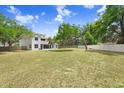 Spacious backyard with a large grassy area, mature trees, and a privacy fence at 808 Hickory Glen Dr, Seffner, FL 33584