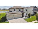 An aerial view of a two story home that features an attached three car garage and manicured lawn at 9287 Crescent Ray Dr, Wesley Chapel, FL 33545