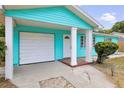 Inviting home exterior featuring a covered entry, attached garage, and a well-maintained, cozy front yard at 115 S Saturn Ave, Clearwater, FL 33755
