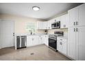 Well-lit kitchen featuring white cabinets, stainless steel appliances, and stylish countertops, blending style and functionality at 115 S Saturn Ave, Clearwater, FL 33755