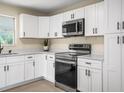 Modern kitchen featuring white cabinets, stainless steel appliances, and sleek countertops providing a clean aesthetic at 115 S Saturn Ave, Clearwater, FL 33755
