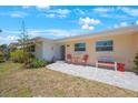 Close-up of a cozy home's entrance featuring a red door, seating, and stone-paved patio at 11619 80Th Ave, Seminole, FL 33772