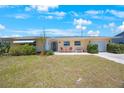 Inviting single-story home with a manicured lawn, quaint seating area, and well-maintained landscaping at 11619 80Th Ave, Seminole, FL 33772