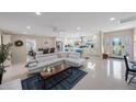Spacious open-concept living area with tile floors, modern white couch, and seamlessly connected kitchen at 11619 80Th Ave, Seminole, FL 33772