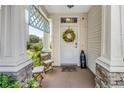Inviting front porch with decorative wreath, seating, and stone accents, creating a cozy entry at 12323 Country White Cir, Tampa, FL 33635
