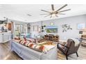 Bright and airy living room featuring modern decor, wood-look flooring, and ample seating for gatherings at 12323 Country White Cir, Tampa, FL 33635