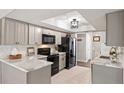 Modern kitchen with stainless steel appliances, grey cabinets and marble countertops at 14542 Anchorage Cir, Seminole, FL 33776