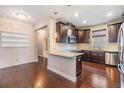 Modern kitchen with dark cabinets, granite countertops, and stainless steel appliances at 19400 Roseate Dr, Lutz, FL 33558
