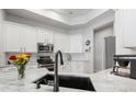 Bright kitchen with white cabinets, stainless steel appliances and modern finishes with view of stainless steel refrigerator at 2402 Blue Stone Ct, Valrico, FL 33594