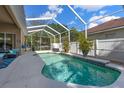 Relaxing screened-in pool with a calming waterfall feature and lush green landscaping providing an idyllic outdoor oasis at 2402 Blue Stone Ct, Valrico, FL 33594