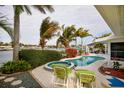 Backyard featuring a pool and hot tub overlooking the water, perfect for relaxing and entertaining at 2487 W Bay Isle Se Dr, St Petersburg, FL 33705