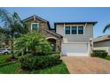 Beautiful two-story home with stone accents, lush landscaping, and a brick paver driveway at 2653 Longleaf Pine Pt, New Port Richey, FL 34655