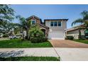 Inviting home with stone details, a manicured lawn, and a brick driveway at 2653 Longleaf Pine Pt, New Port Richey, FL 34655