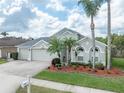 Beautiful single-Gathering home featuring tropical landscaping, a three-car garage, and a well-maintained lawn at 29542 Forest Glen Dr, Wesley Chapel, FL 33543