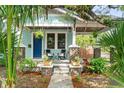 Inviting front porch of a light blue home, perfect for relaxing with outdoor seating and mature landscaping at 3008 N 13Th St, Tampa, FL 33605