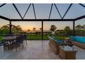 Inviting outdoor seating area with comfortable wicker furniture overlooking serene sunset views at 3303 Monroe Meadows Dr, Odessa, FL 33556