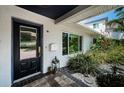 Inviting entrance featuring a stylish front door, elegant lantern, and lush landscaping at 333 Belleair Ne Dr, St Petersburg, FL 33704