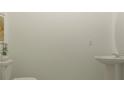 Simple powder room with pedestal sink, modern fixtures, and neutral wall color at 36013 Joseph Blake St, Zephyrhills, FL 33541