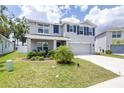Two-story home with a well-kept lawn, lush landscaping, attached garage, and inviting curb appeal at 36398 Spanish Rose Dr, Dade City, FL 33525