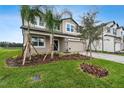 Two-story home featuring stone accents, a two-car garage, and a well-manicured lawn at 38190 Shale Stone Ct, Zephyrhills, FL 33540