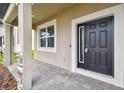 Elegant front door with sidelight, framed by white trim and stone-accented columns at 38190 Shale Stone Ct, Zephyrhills, FL 33540
