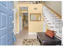 Spacious foyer with tile flooring, staircase, and a bench, illuminated by natural light at 4180 Jacaranda Cir, Brooksville, FL 34604