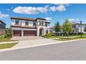 Gorgeous curb appeal with a two-story home, 3-car garage, and lush landscaping on a sunny day at 4275 Burdick Loop, Odessa, FL 33556