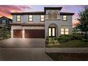Beautiful two-story home boasts a 3-car garage and lush landscaping, captured at twilight at 4275 Burdick Loop, Odessa, FL 33556
