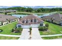 Stunning aerial view of the home with a pond, pristine landscaping, and an elongated brick driveway at 4300 Barletta Ct, Wesley Chapel, FL 33543