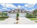 Beautiful single-story home with a three-car garage, a well-manicured lawn, and a charming brick driveway at 4300 Barletta Ct, Wesley Chapel, FL 33543