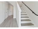 Modern staircase with sleek handrail, complemented by pristine white walls and light wood floors at 4717 W Mccoy St # 2, Tampa, FL 33616